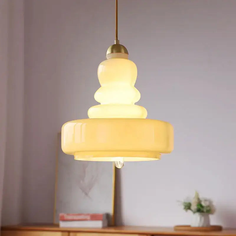 Tiered yellow glass pendant lights with brass accents for kitchens
