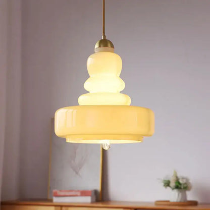 Tiered yellow glass pendant lights with brass accents for kitchens