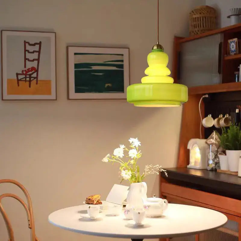 Tiered yellow glass pendant lights with brass accents for kitchens