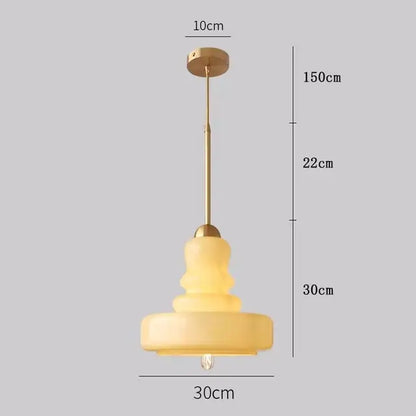 Tiered yellow glass pendant lights with brass accents for kitchens