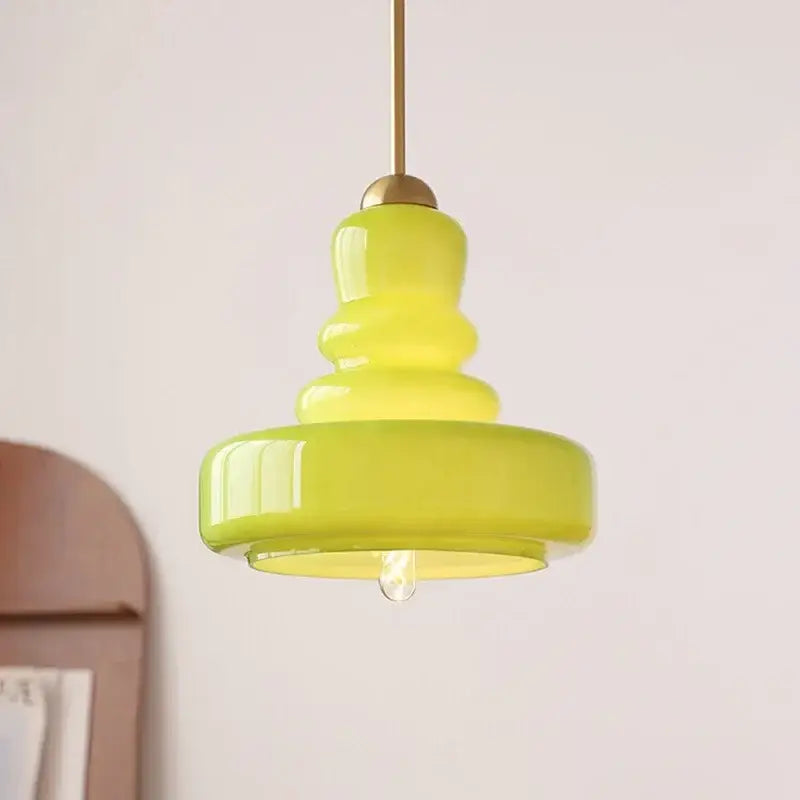 Tiered yellow glass pendant lights with brass accents for kitchens