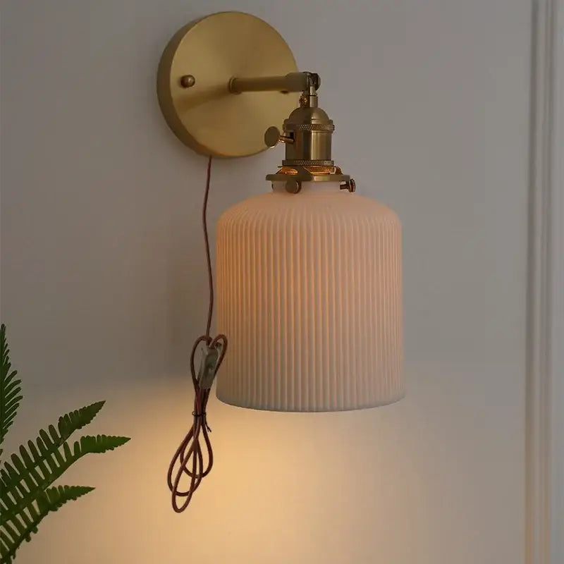 Vintage brass wall light with ribbed glass and knob switch bedroom