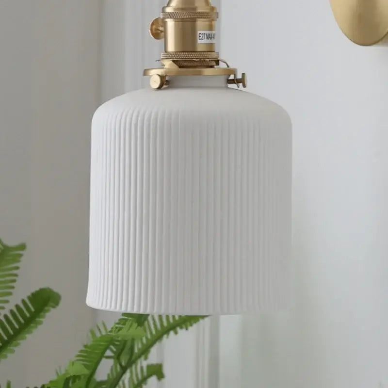 Vintage brass wall light with ribbed glass and knob switch bedroom
