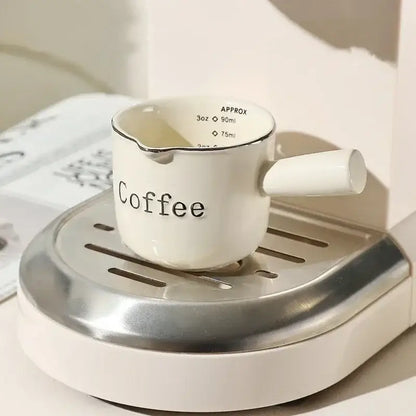 White ceramic espresso measuring cup and milk pitcher kitchen decor
