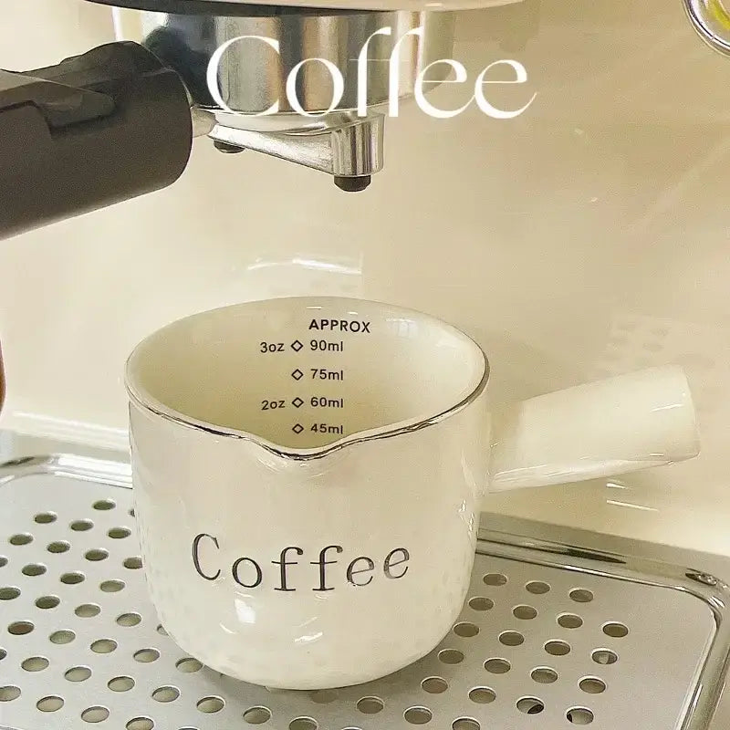 White ceramic espresso measuring cup and milk pitcher kitchen decor