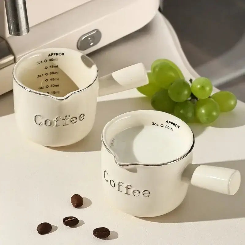 White ceramic espresso measuring cup and milk pitcher kitchen decor