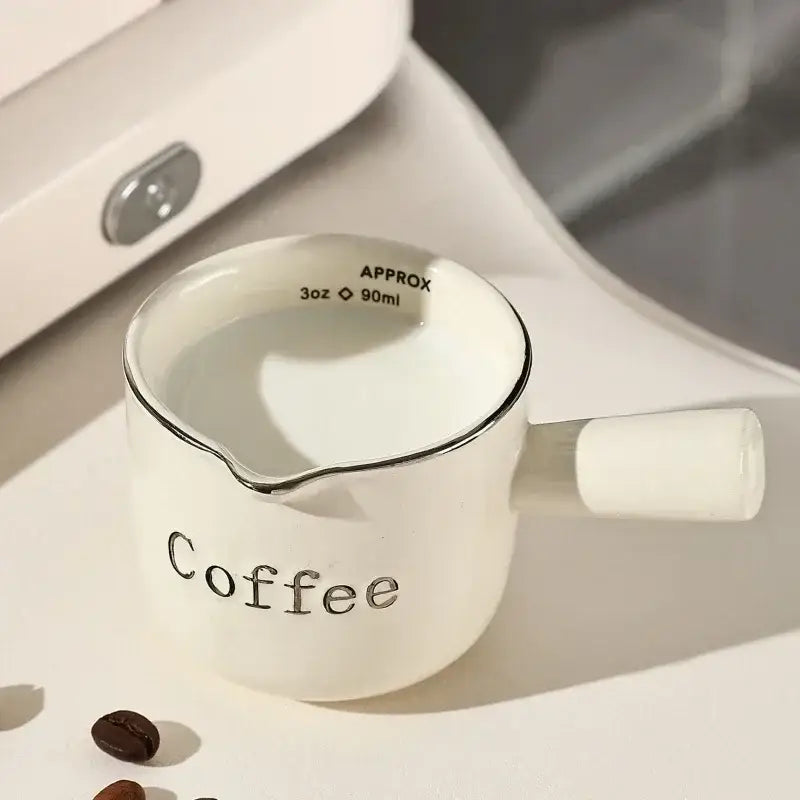 White ceramic espresso measuring cup and milk pitcher kitchen decor