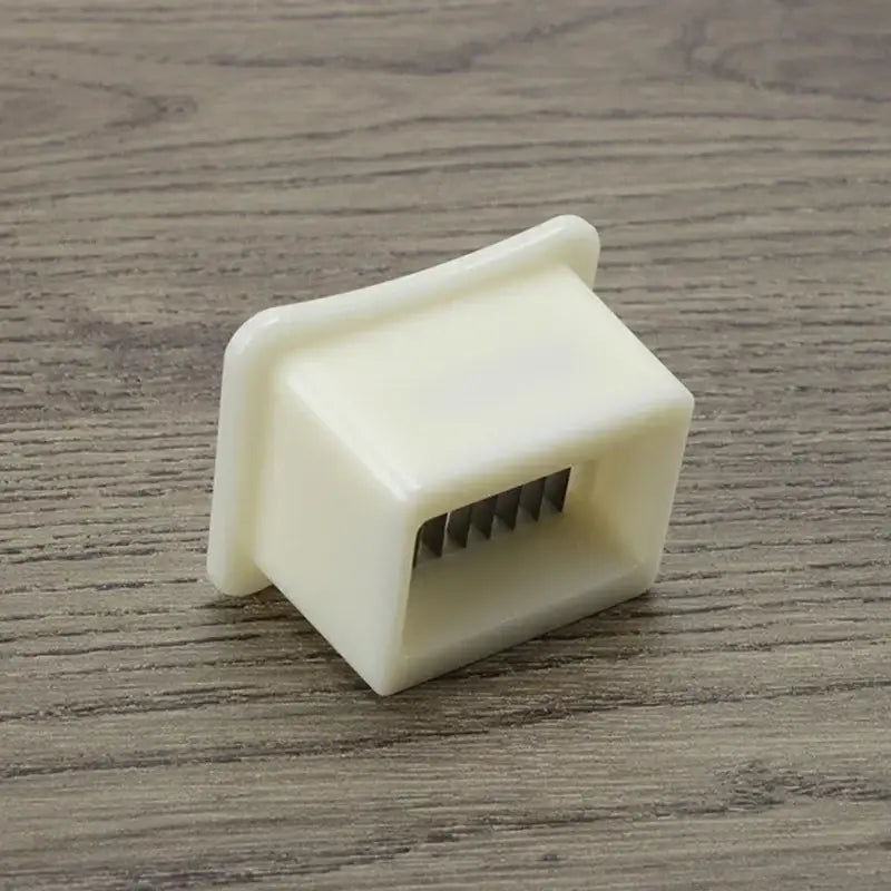 White plastic green bean slicer with metal blades kitchen shredder